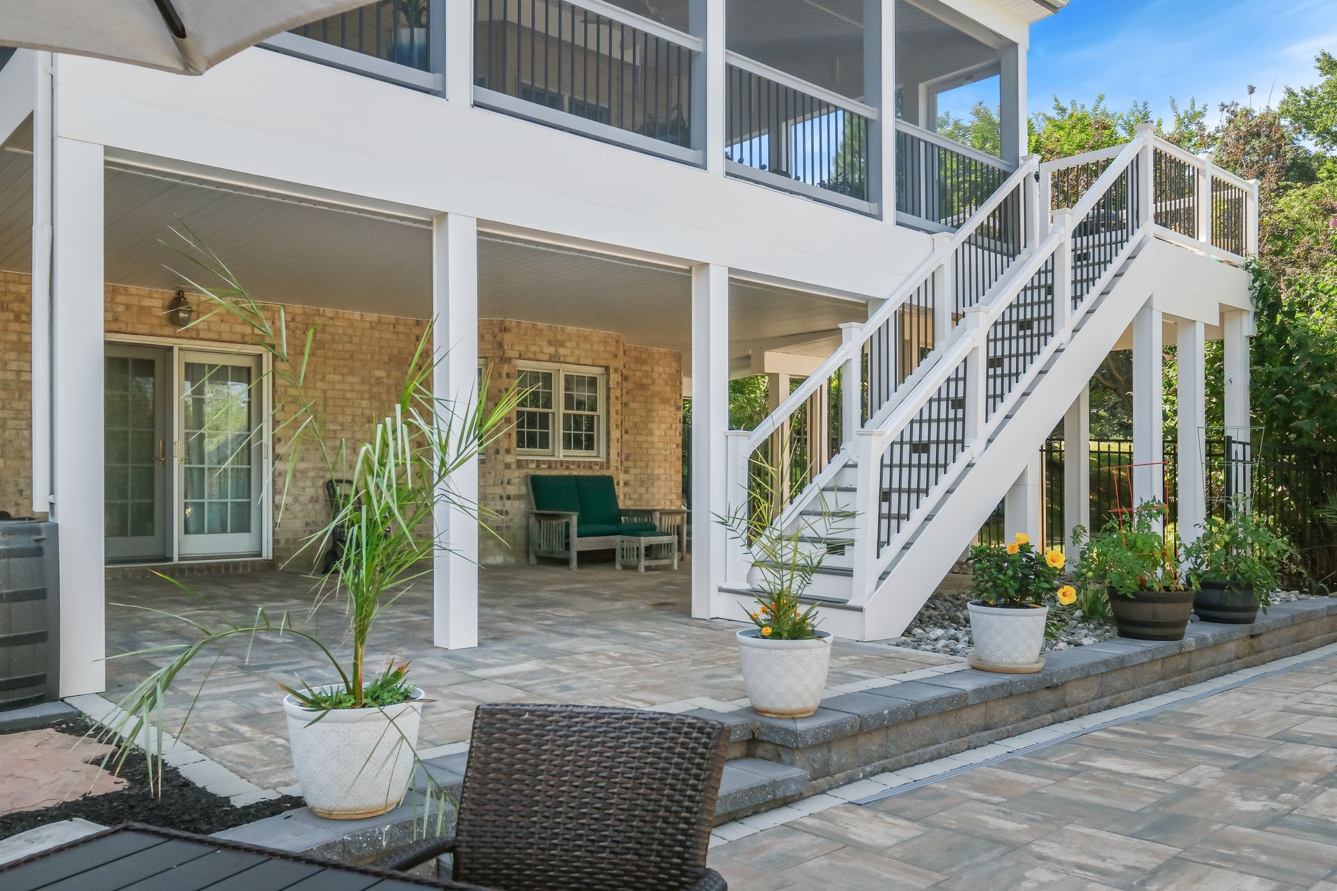 A large house with a screened in porch and stairs leading up to it.