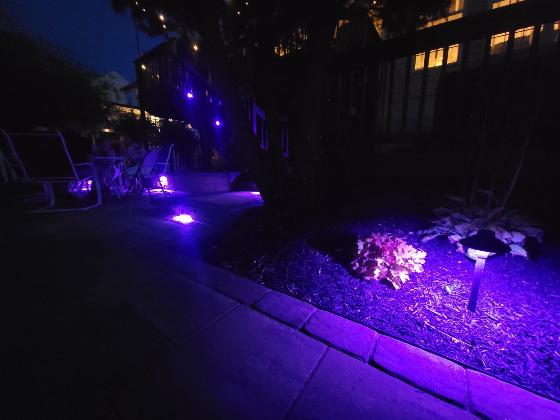 A patio with purple lights on it at night.