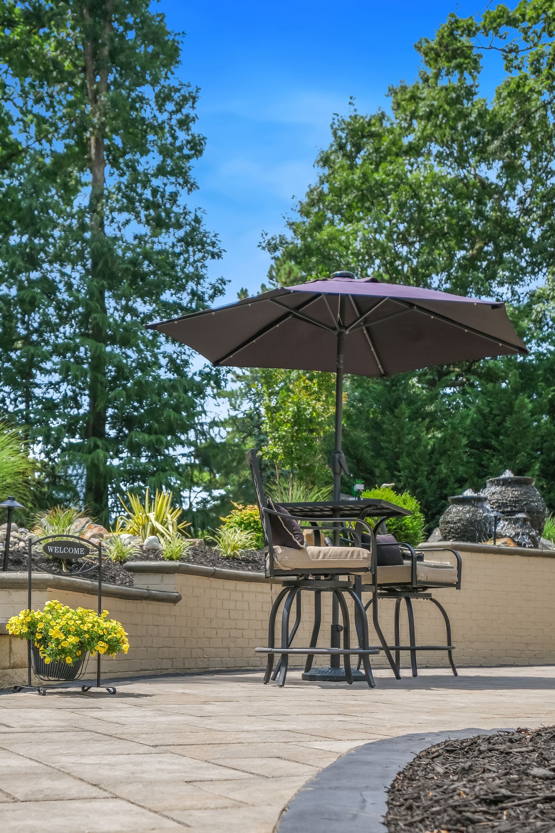 A patio with a table and chairs and an umbrella.