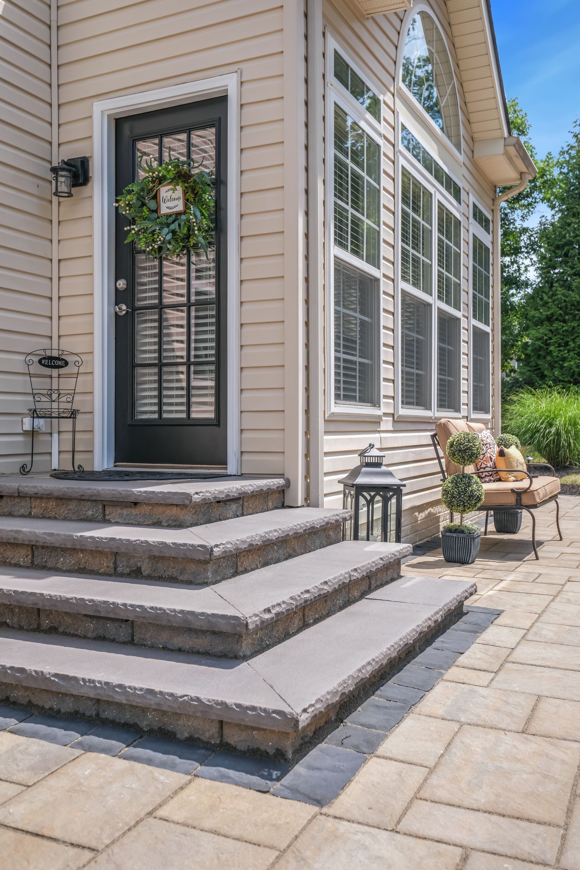 A patio with tables , chairs , umbrellas and a fire pit.