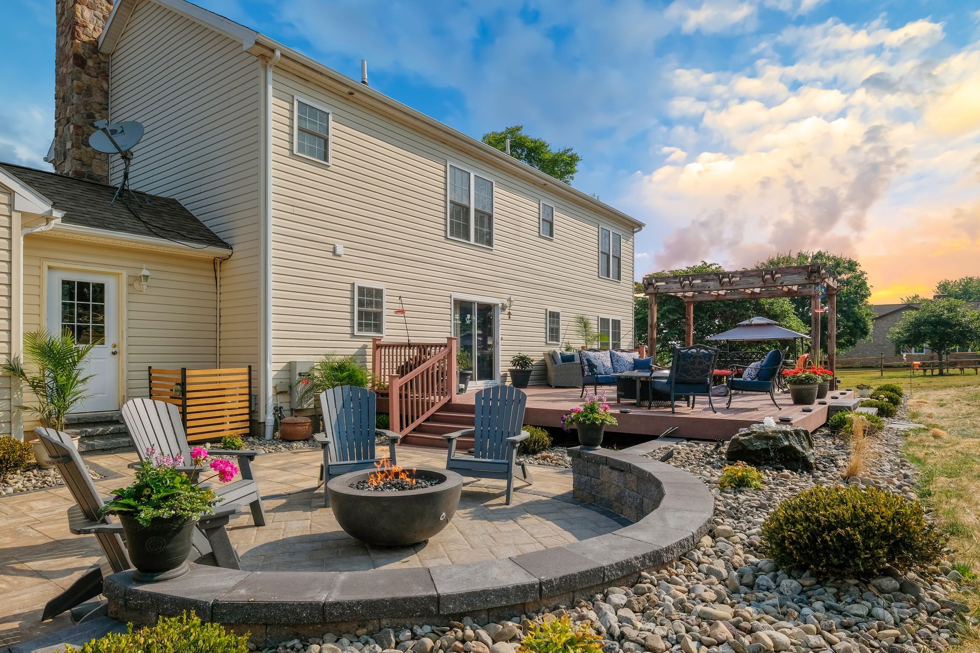 A large house with a patio and a fire pit in front of it.