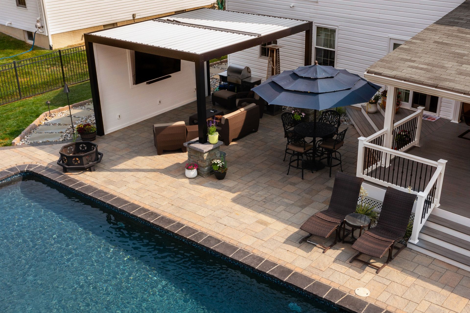 An aerial view of a patio with a swimming pool and umbrellas.