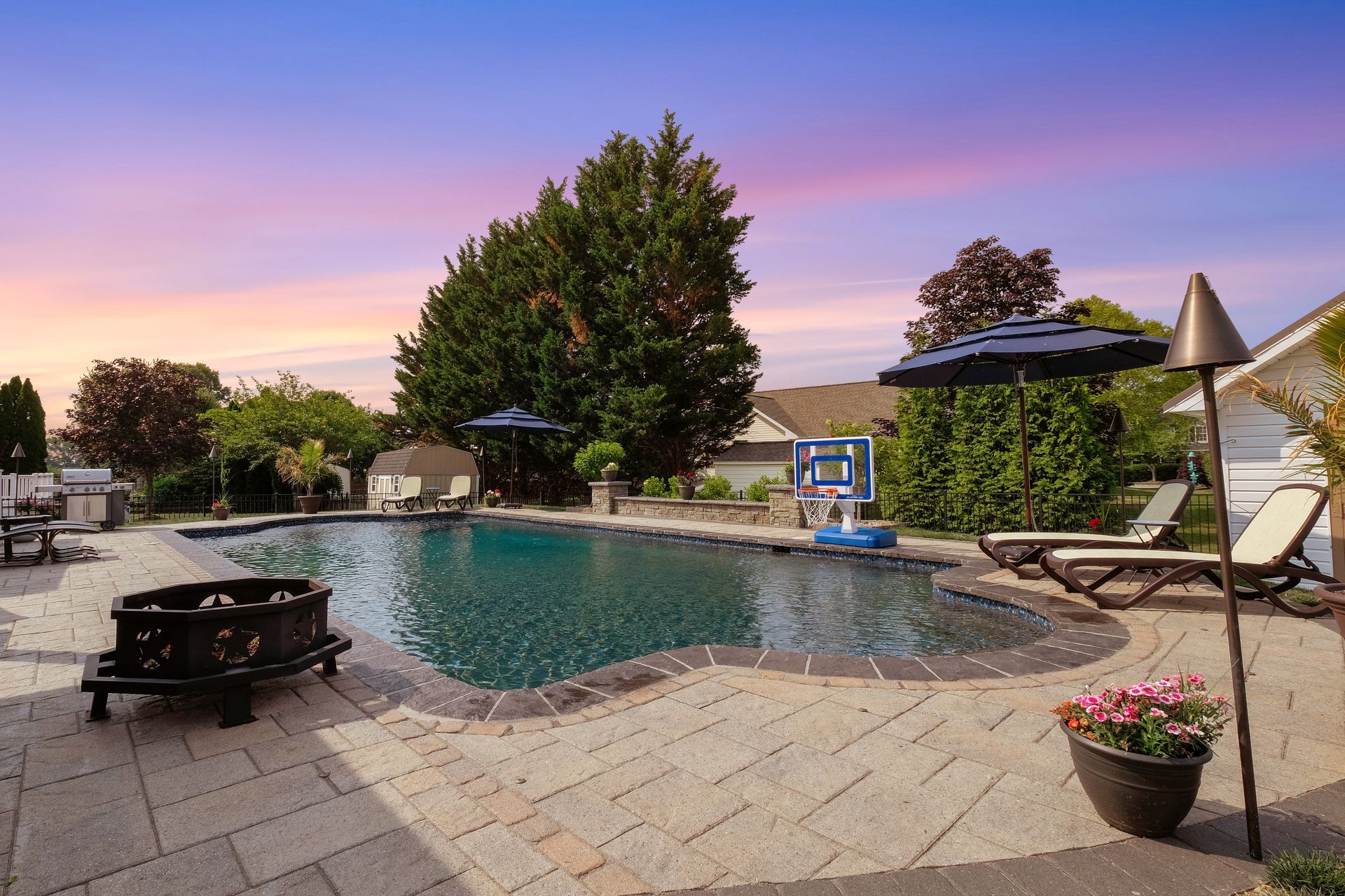 A large swimming pool is surrounded by chairs and umbrellas