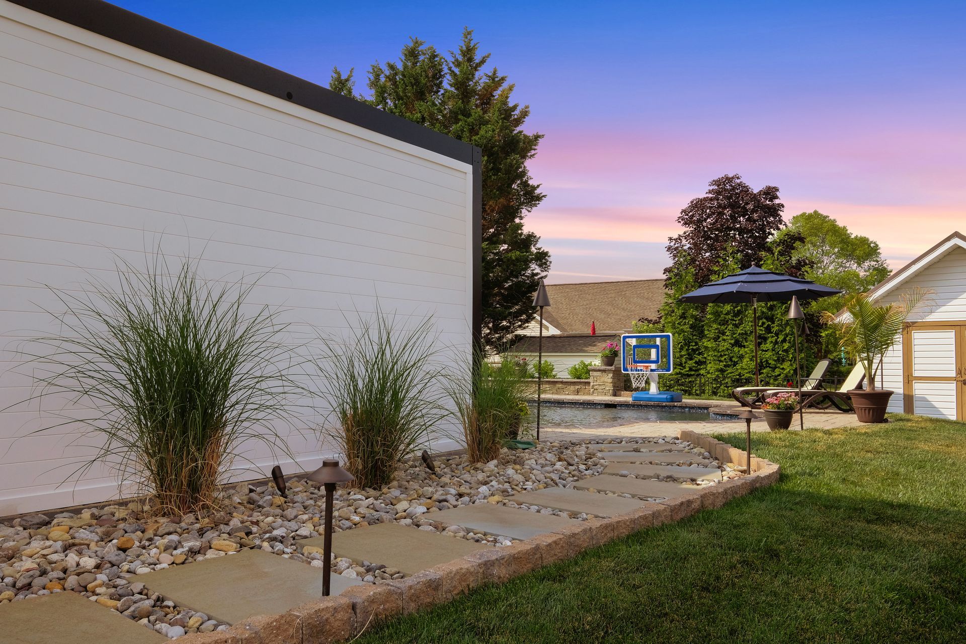 There is a swimming pool in the backyard of a house.