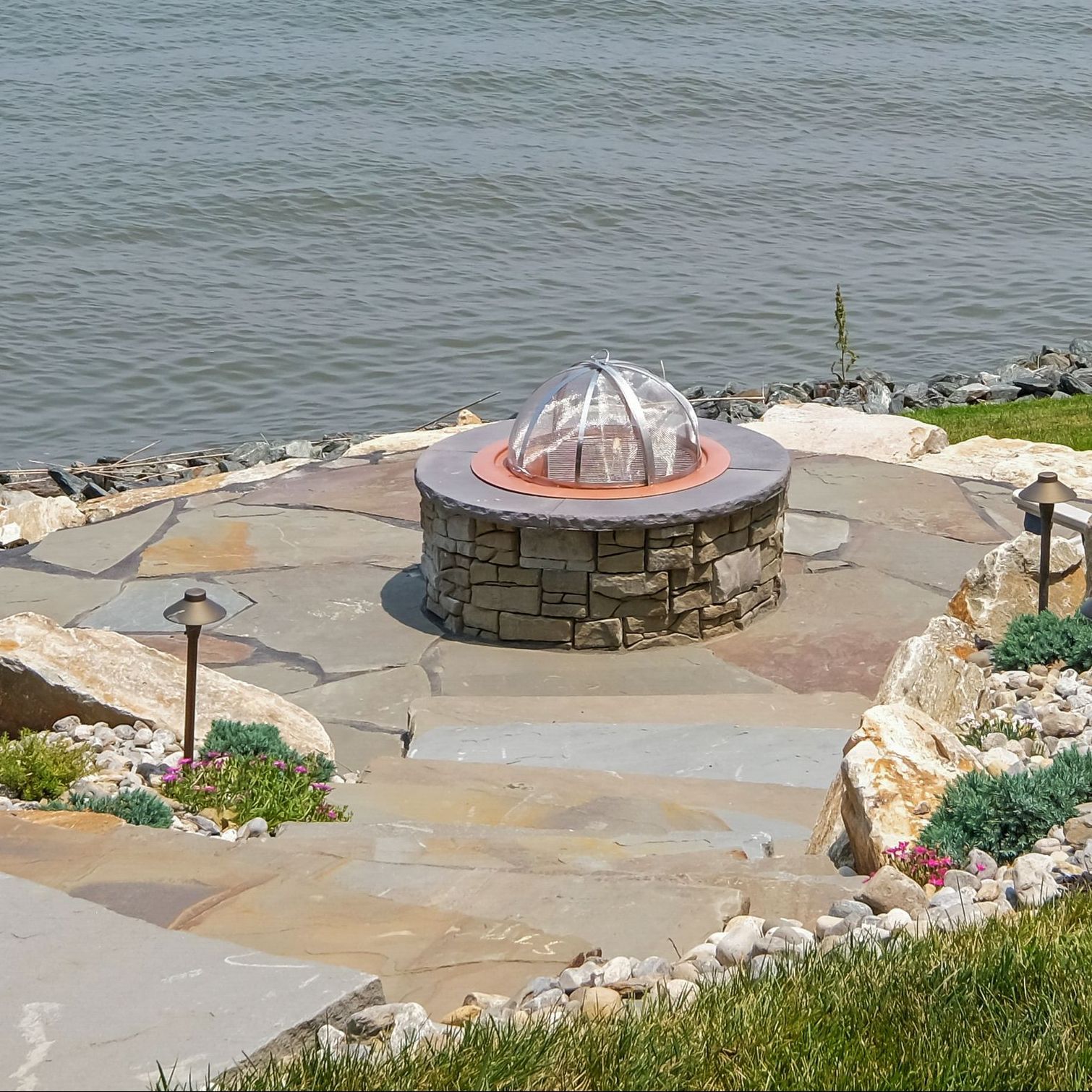 Elegant, rustic stone steps descending to a cozy fire pit space perfect for outdoor gatherings