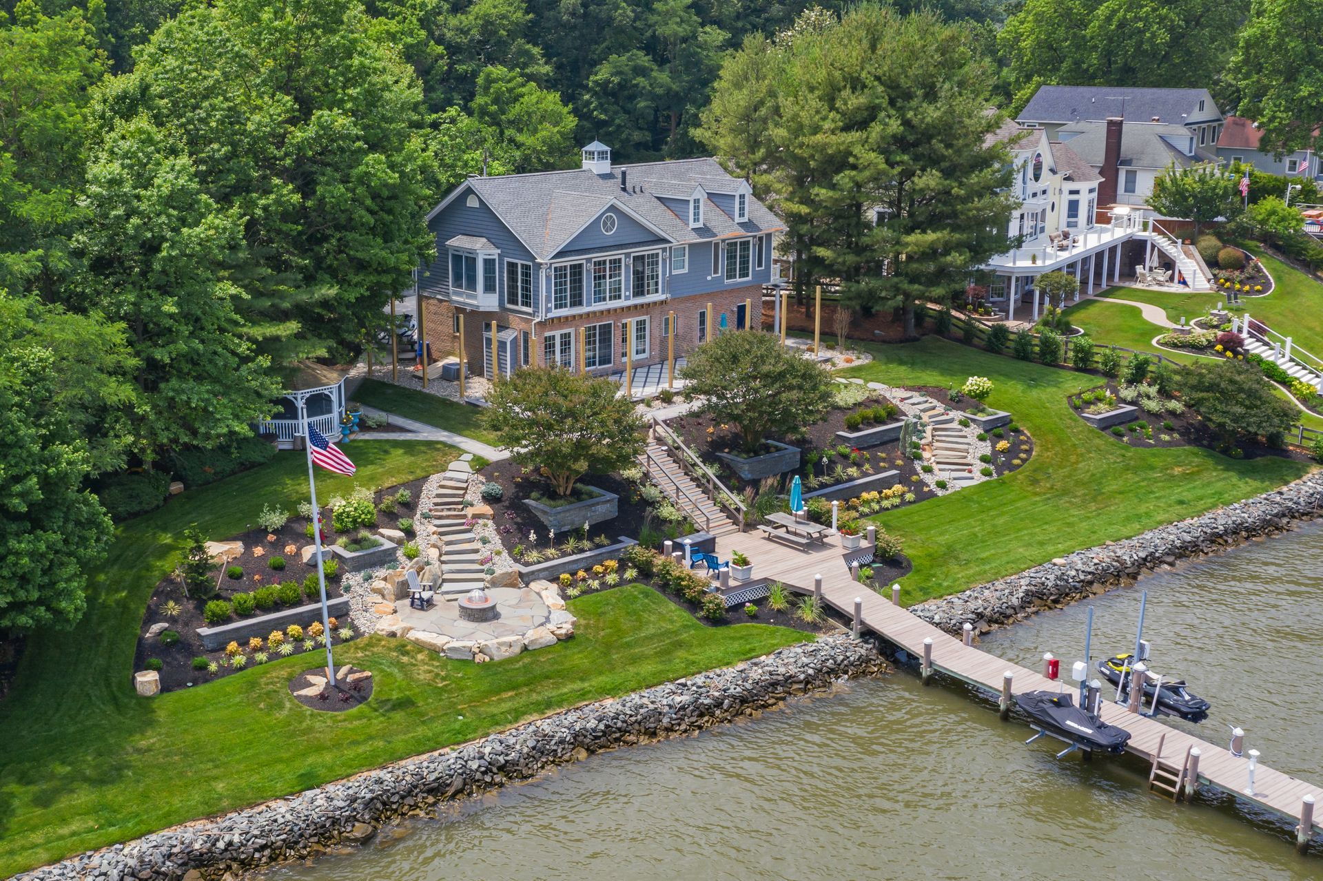 An aerial view of a large house next to a body of water.
