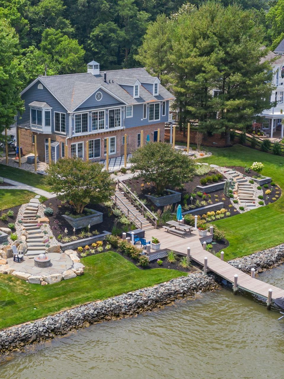 An aerial view of a large house next to a body of water.