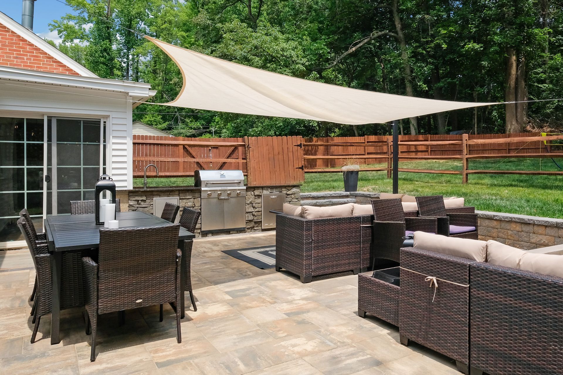 A patio with a table and chairs and an umbrella in front of a house.