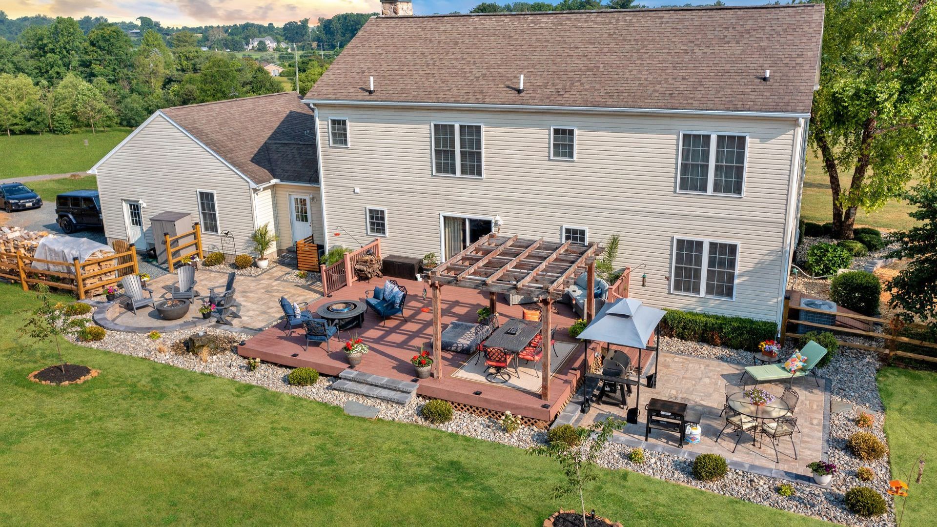 Beautiful outdoor living space by Bayside Outdoor Living with a deck, patio, pergola and fire pit