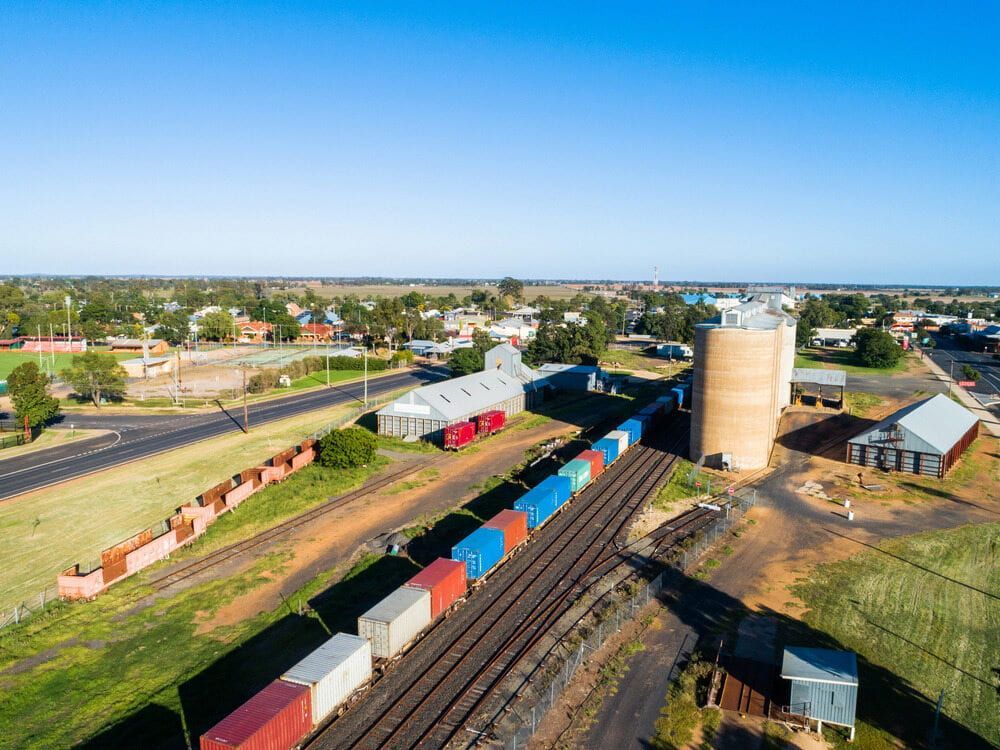 An Aerial View Of A Train Going Down Train Tracks In A Small Town — Central West Budget Tree Services in Narromine, NSW