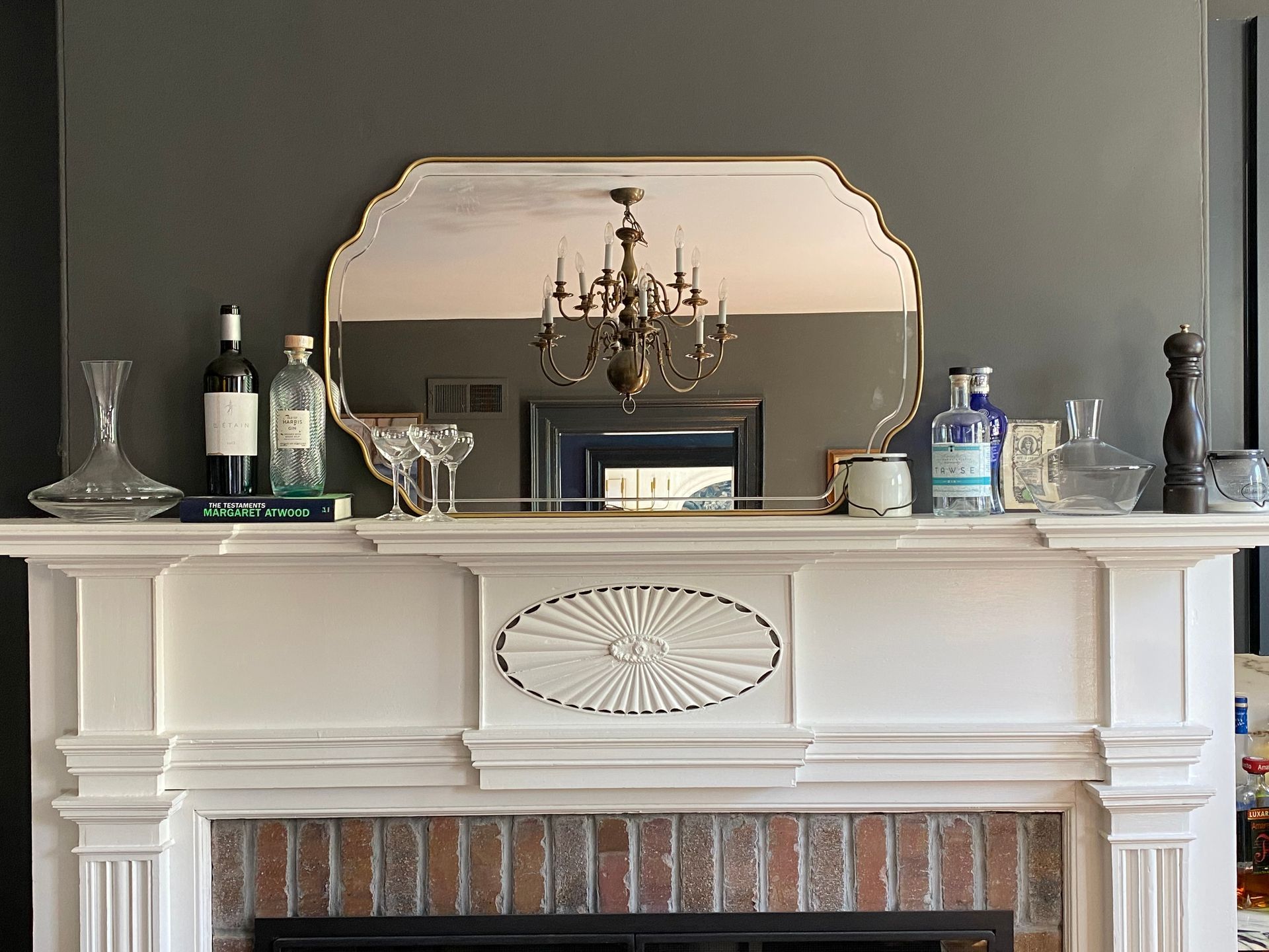 Fireplace with white mantel, mirror, and decorative items; dark gray wall.
