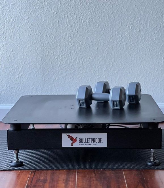 A vibration plate with dumbbells on top of it