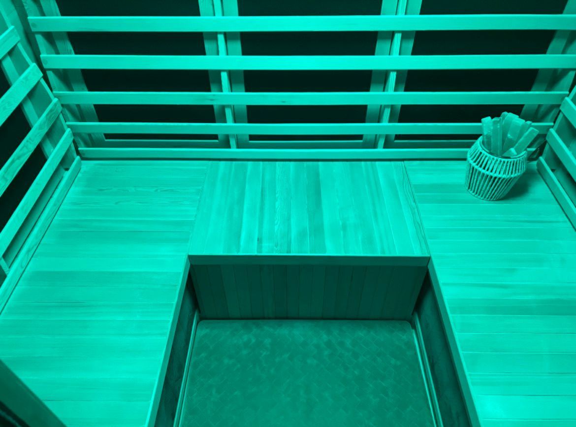 A wooden sauna with green light.