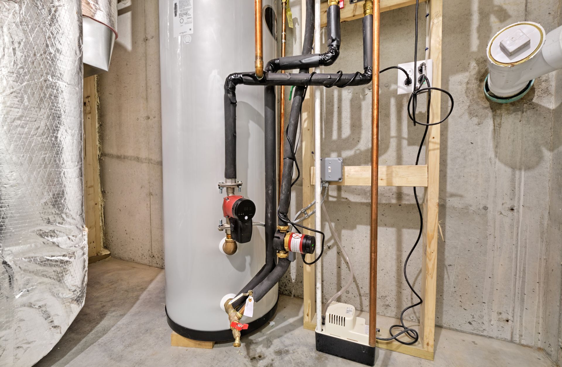 Basement utility room with water heater, pipes, wiring, and exposed concrete walls. Basement utility room with water heater, pipes, wiring, and exposed concrete walls.