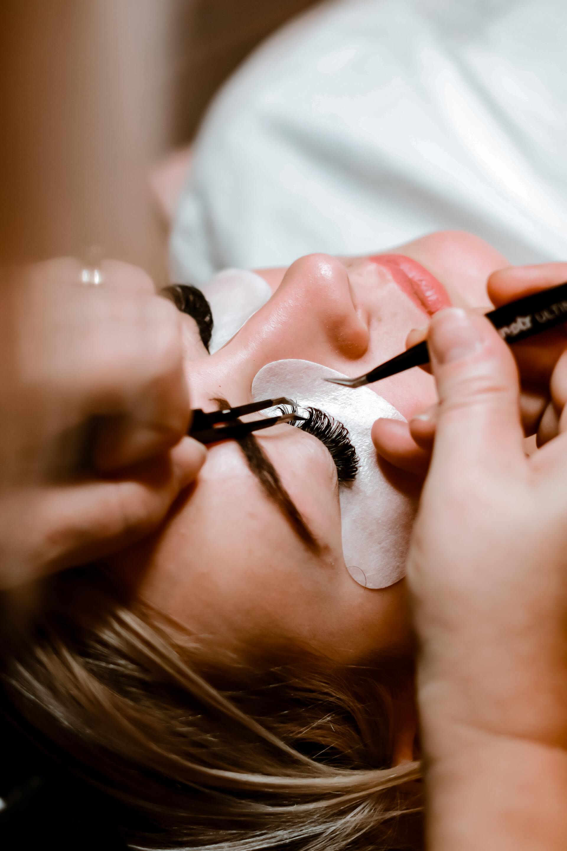 A woman is getting her eyelashes done at a beauty salon.