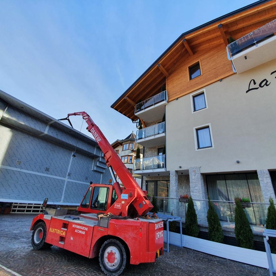 Gru elettrica in sollevamento vicino a villa