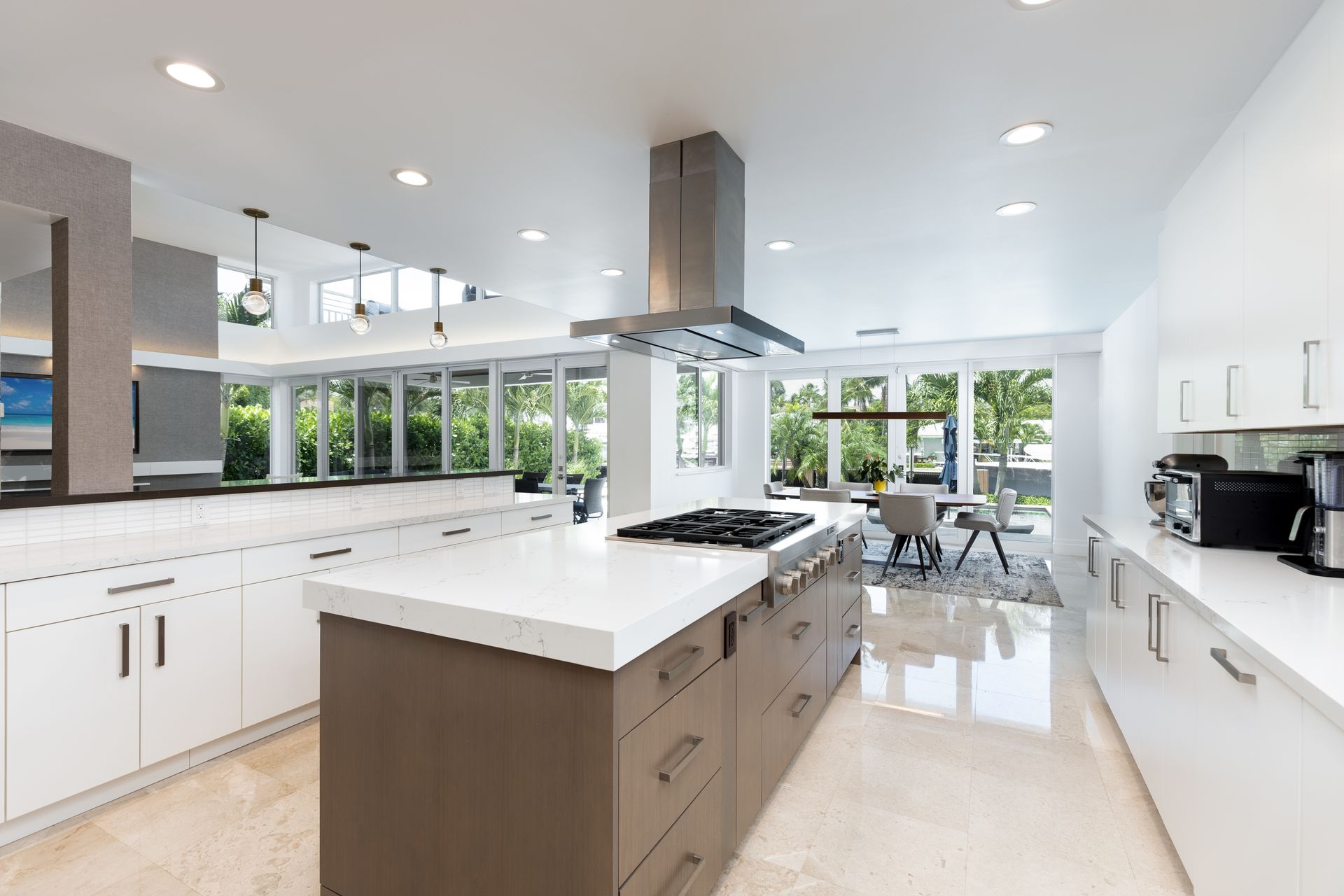 A kitchen with white cabinets and a large island in the middle