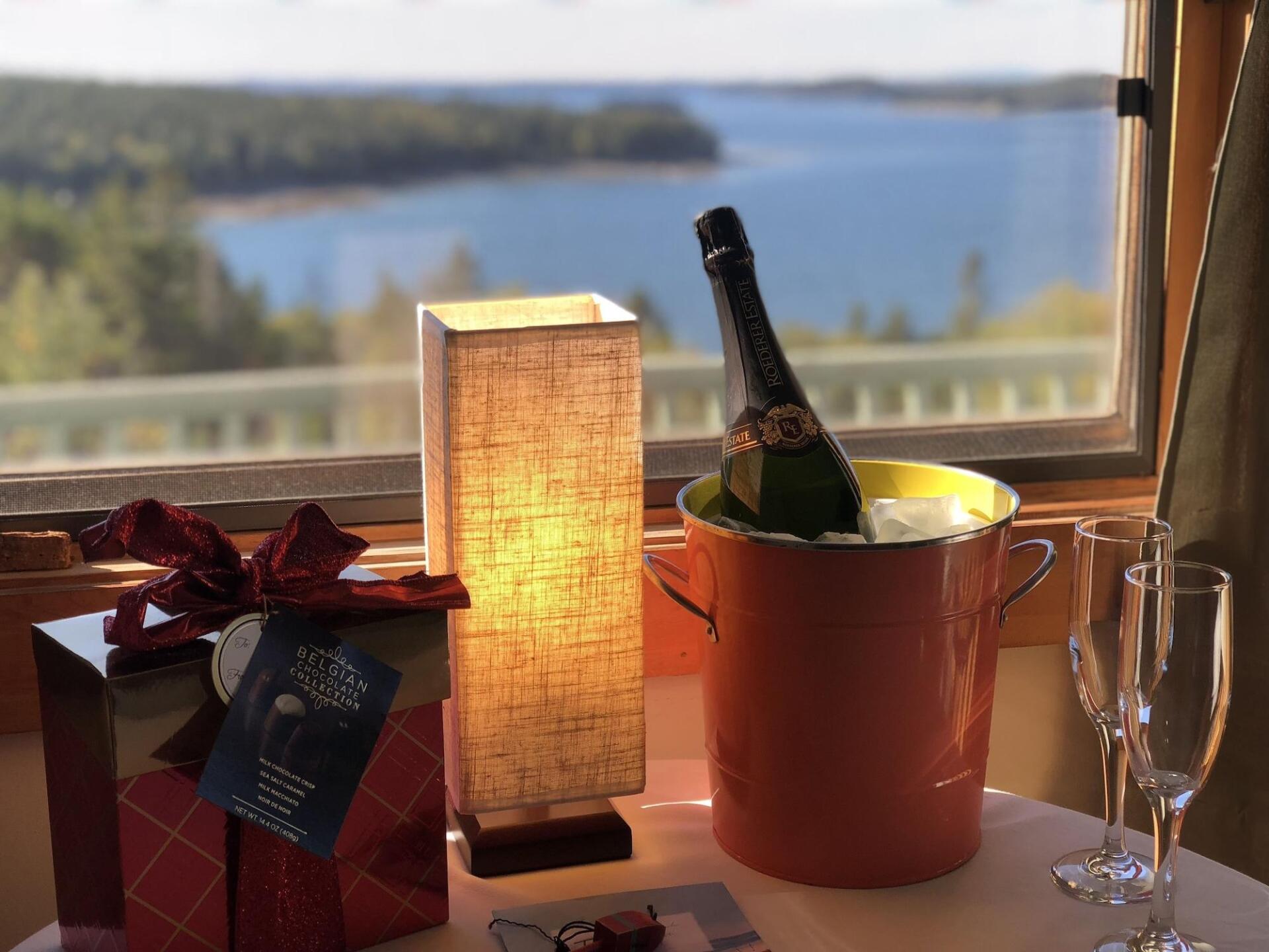 A table with a bucket of ice and a bottle of champagne on it.