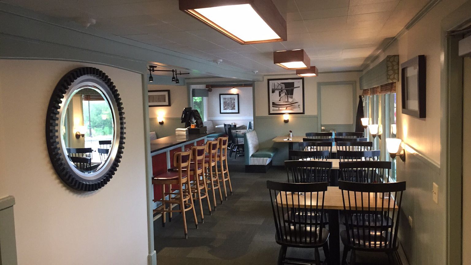 A restaurant with tables and chairs and a mirror on the wall