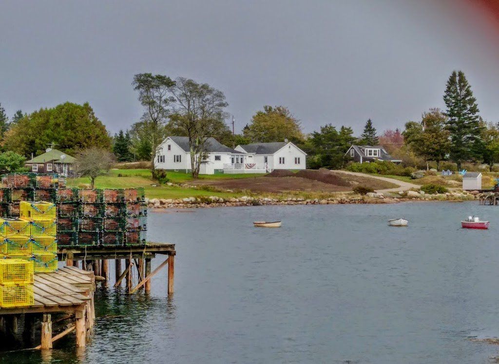 A large body of water with a dock in the foreground and a house in the background