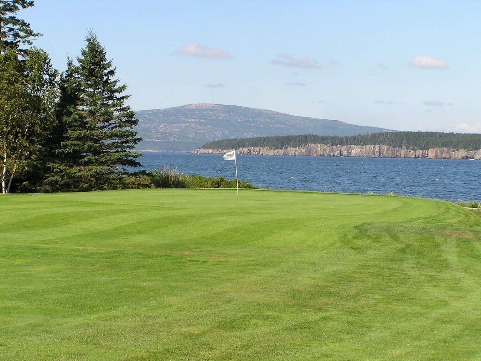 A golf course with a lake in the background