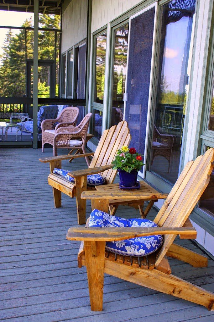 A patio with chairs and a table with flowers on it