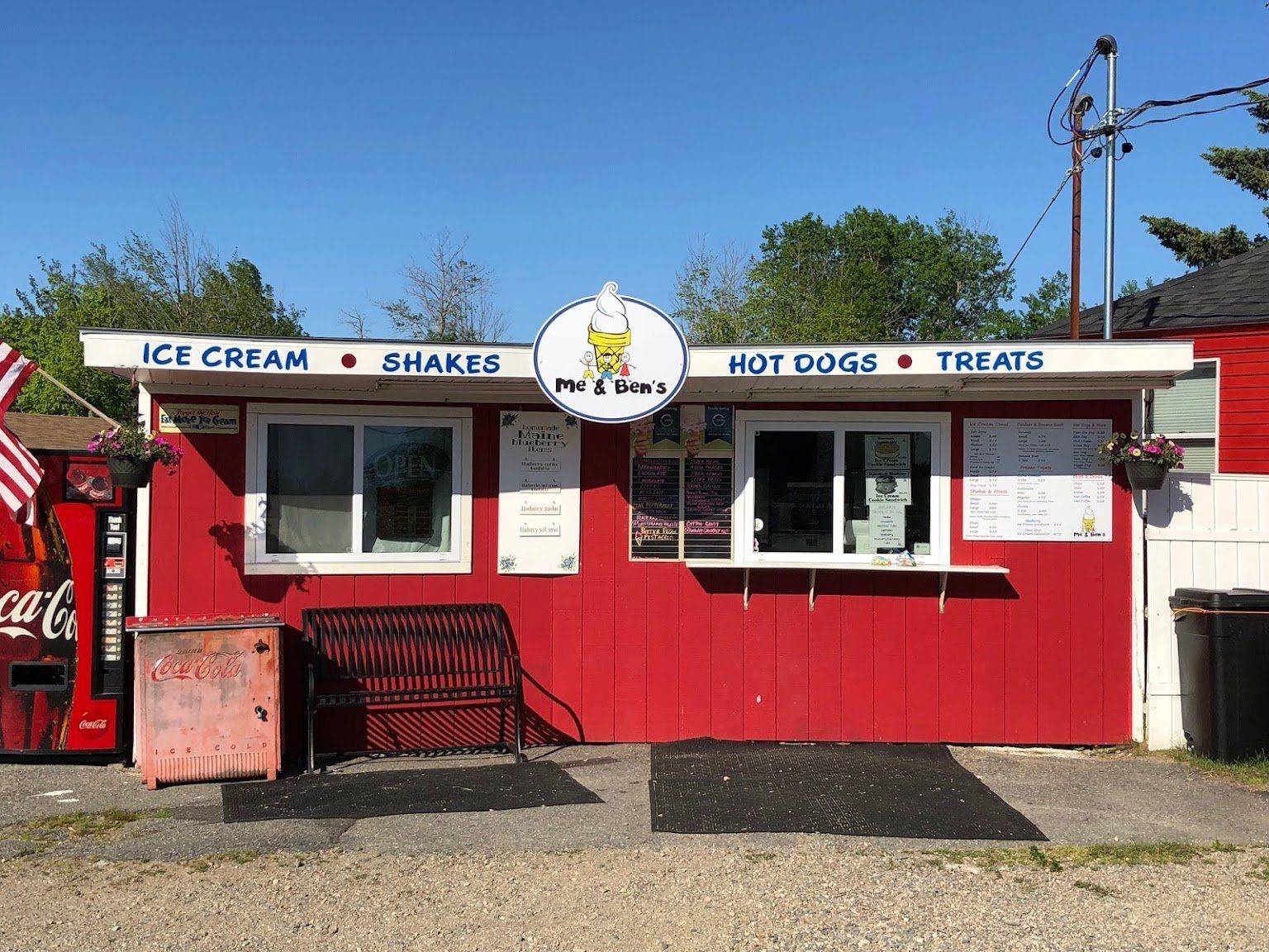 A red and white building with a sign that says ice cream shakes hot dogs and treats.