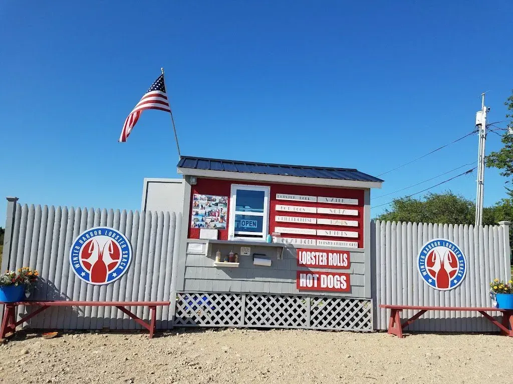 A small red and white building with an american flag hanging from the roof.