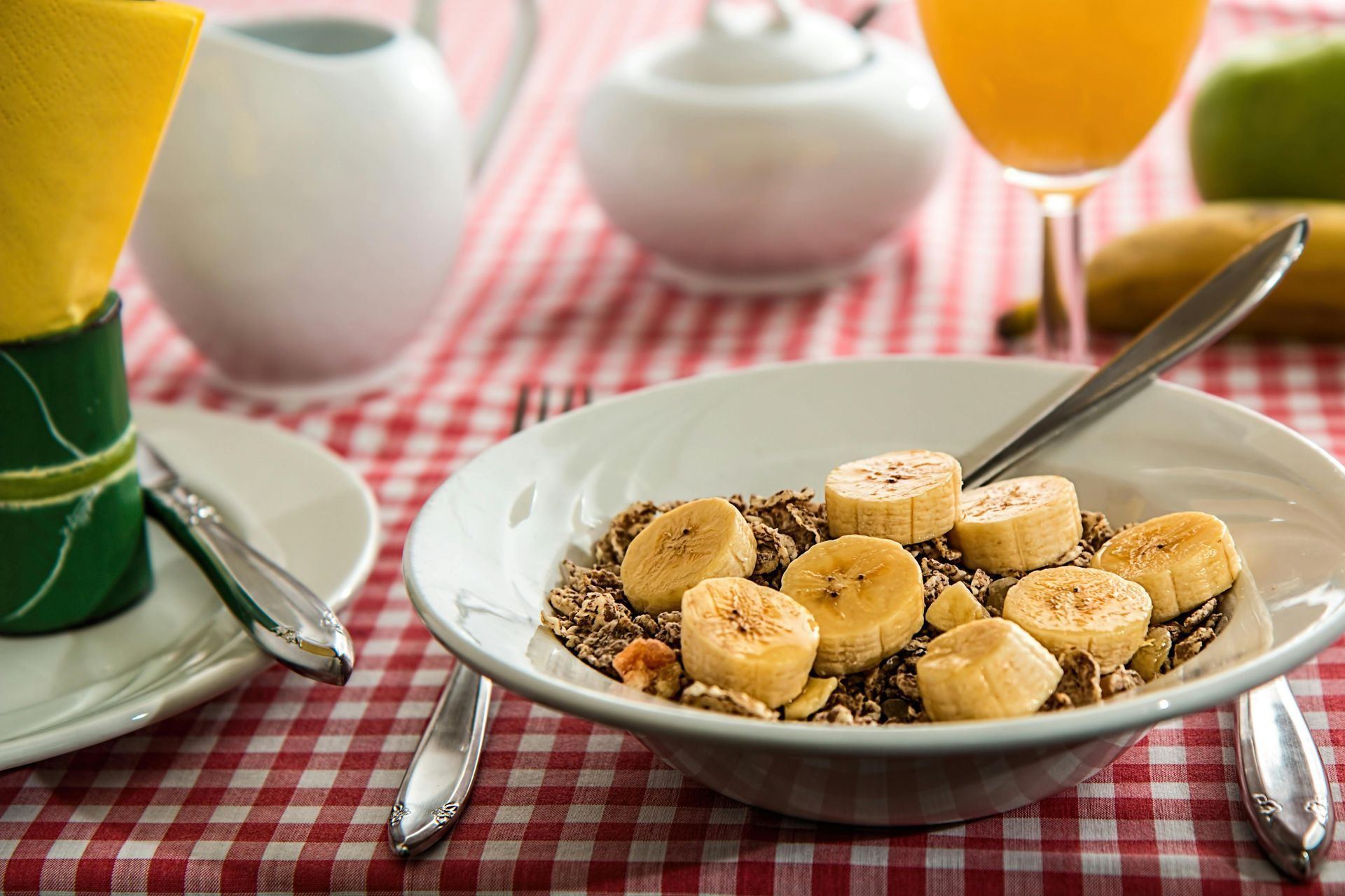 A bowl of strawberries sits on a table next to a bowl of fruit.