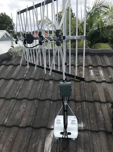 An Antenna Is Sitting On Top Of A Tiled Roof — Coastwide Antennas In Ourimbah, NSW