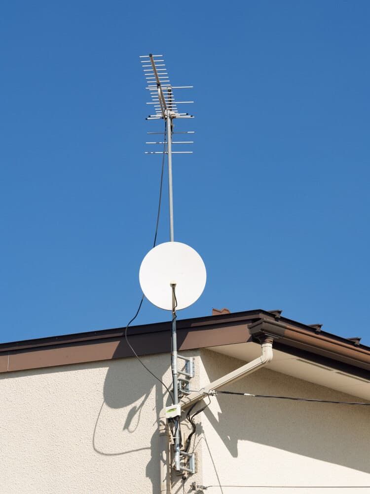 A Satellite Dish Is Attached To The Side Of A Building — Coastwide Antennas In Wyong, NSW
