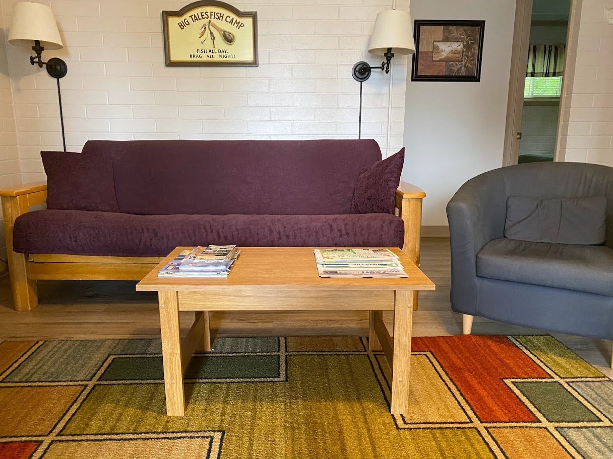 A living room with a purple futon and a gray chair
