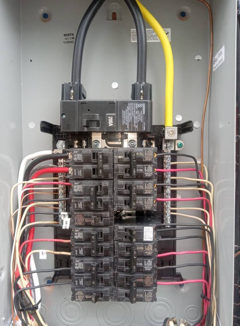 A close up of an electrical panel with a yellow wire coming out of it