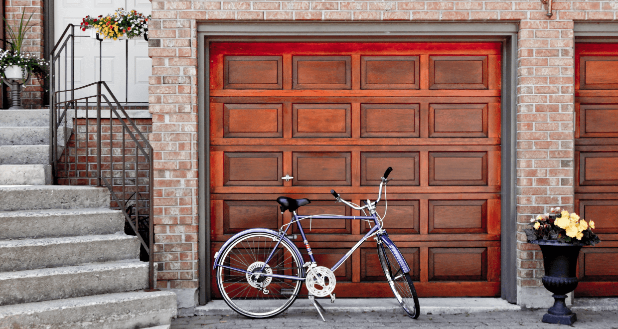 A bicycle is parked in front of a garage door.