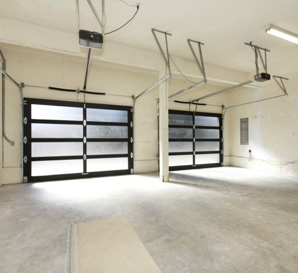 A garage with two garage doors and a ceiling lift