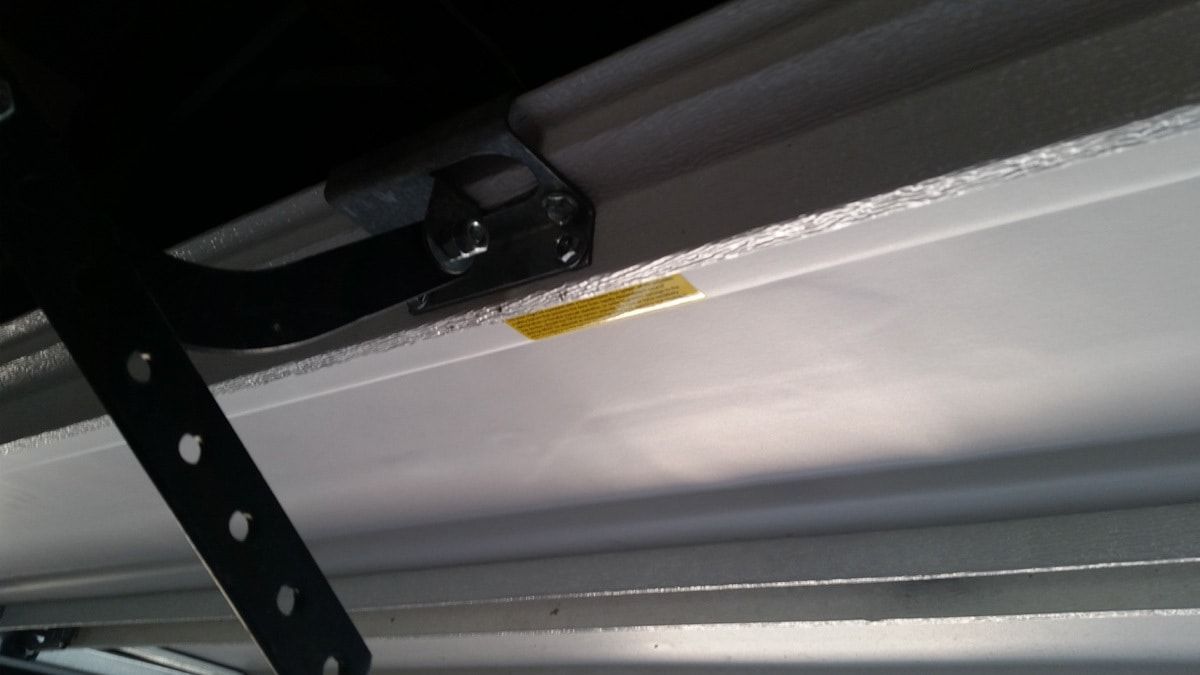 A close up of a garage door with a yellow sticker on it