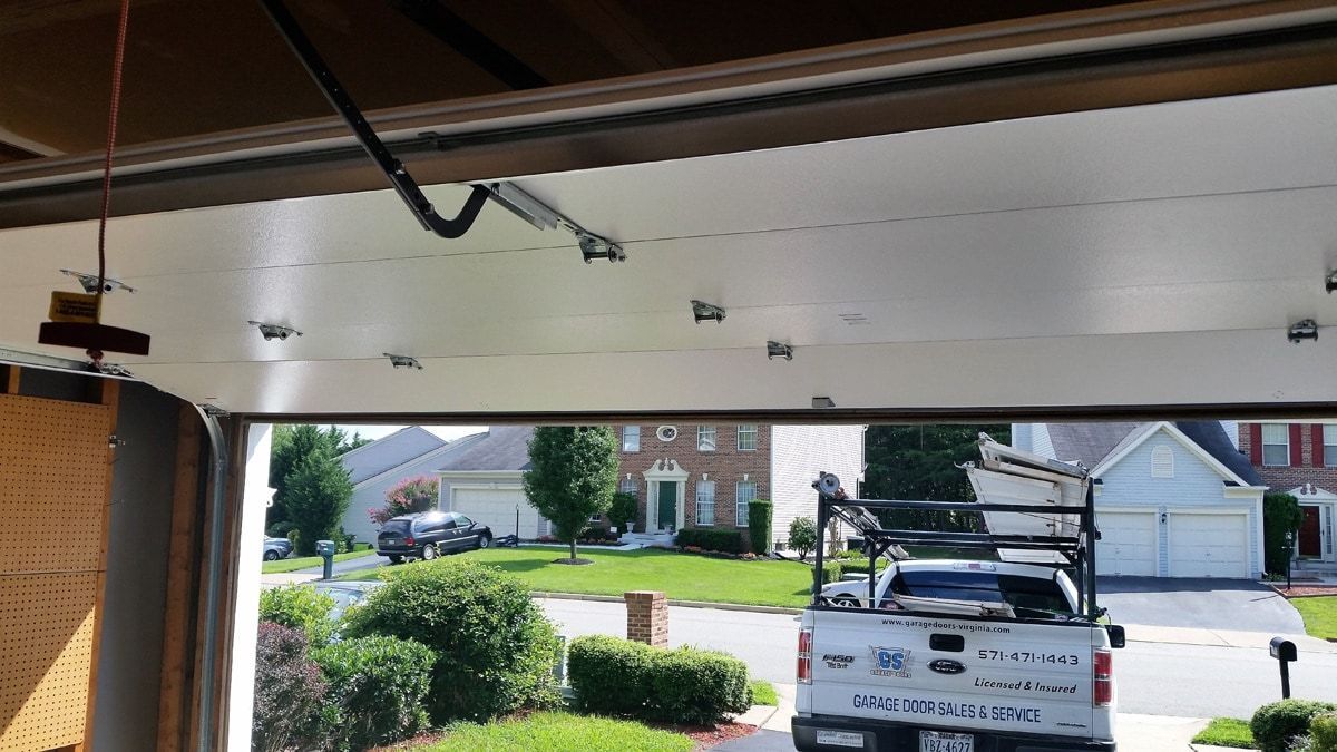 A truck is parked in a garage next to a house.