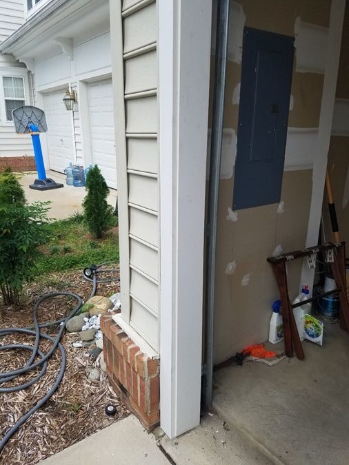A garage door is open and a basketball hoop is in the background.