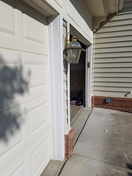 A white garage door with a lamp on the side of it