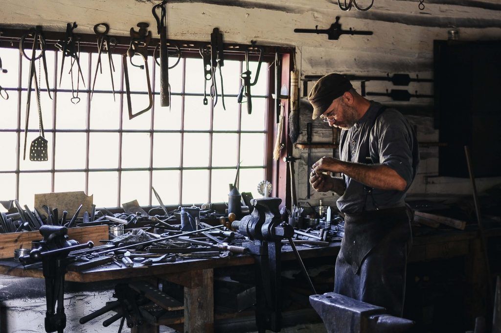 A man is working on a piece of metal in a workshop