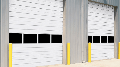 a row of white garage doors with black squares on them .