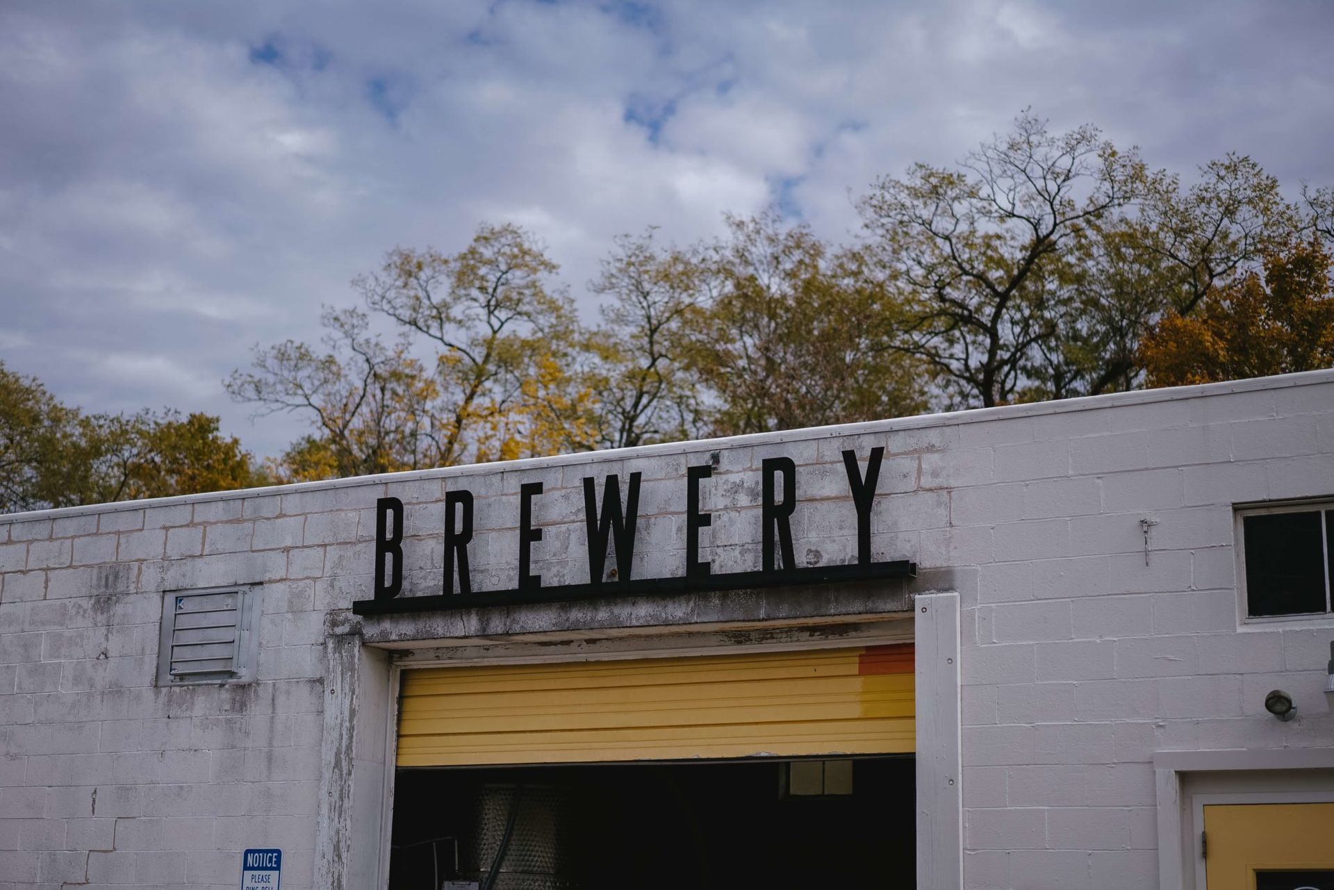 A white brick building with a brewery sign on it.