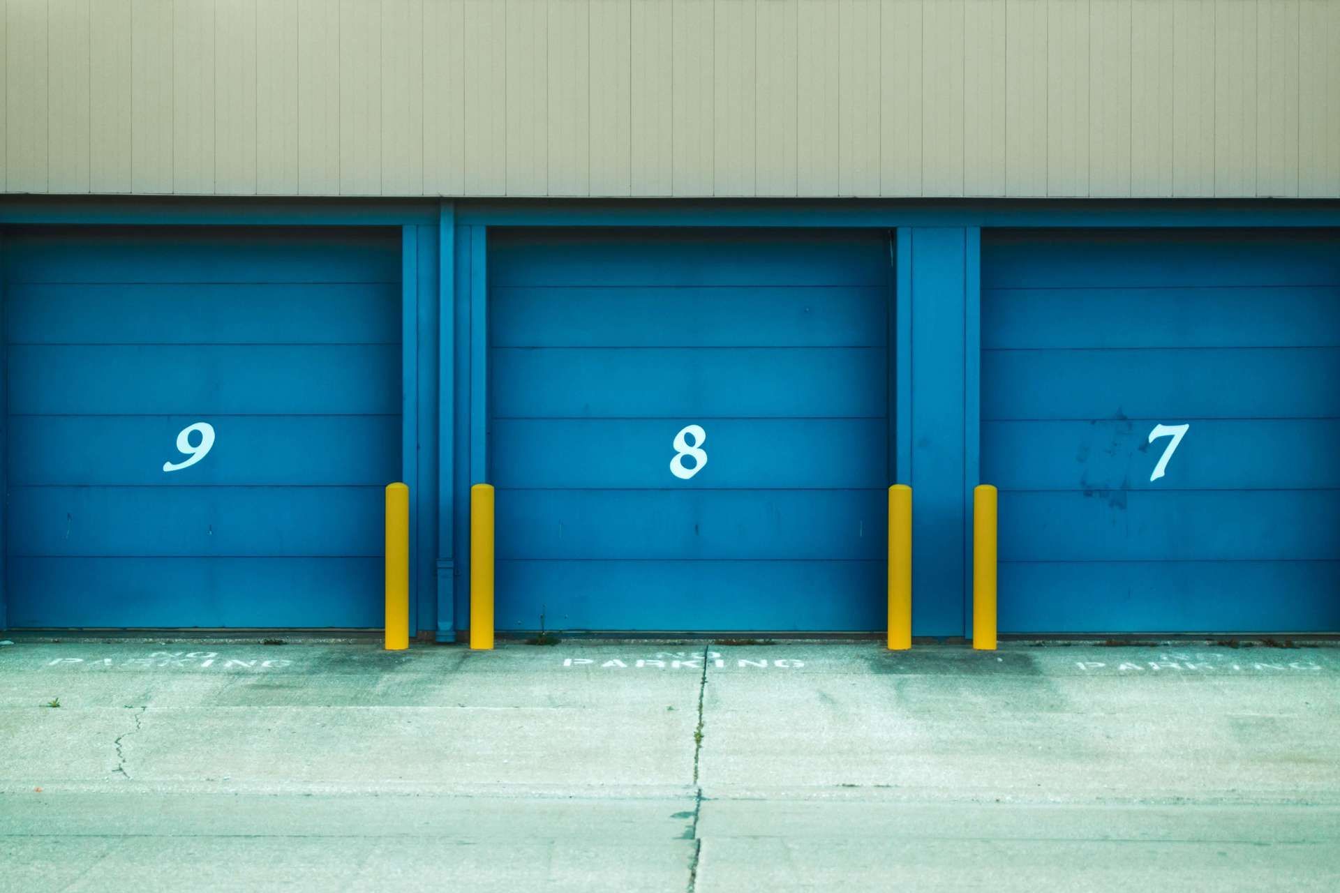 Three blue garage doors with the numbers 9 8 and 7 on them
