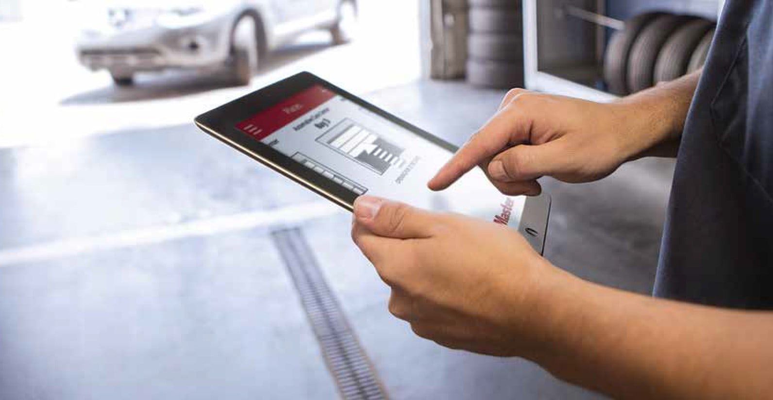 a man is using a tablet computer in a garage .