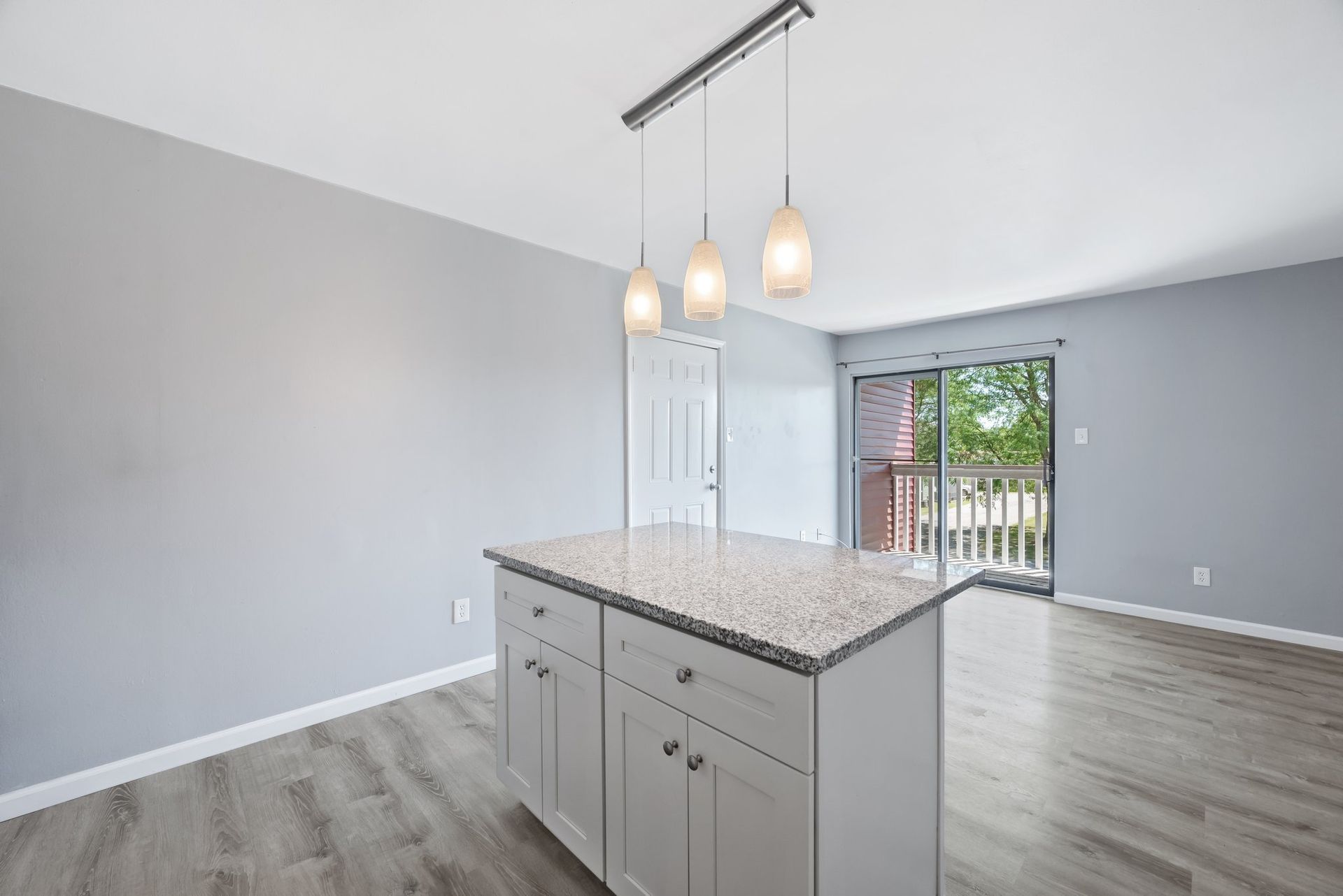 An empty kitchen with a large island in the middle of the room.