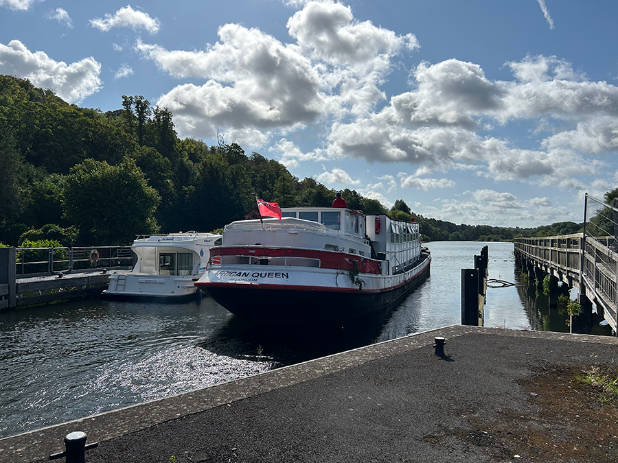A red and white boat in the lock at Henley.