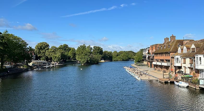 A large body of water surrounded by houses and trees on a sunny day in Windsor