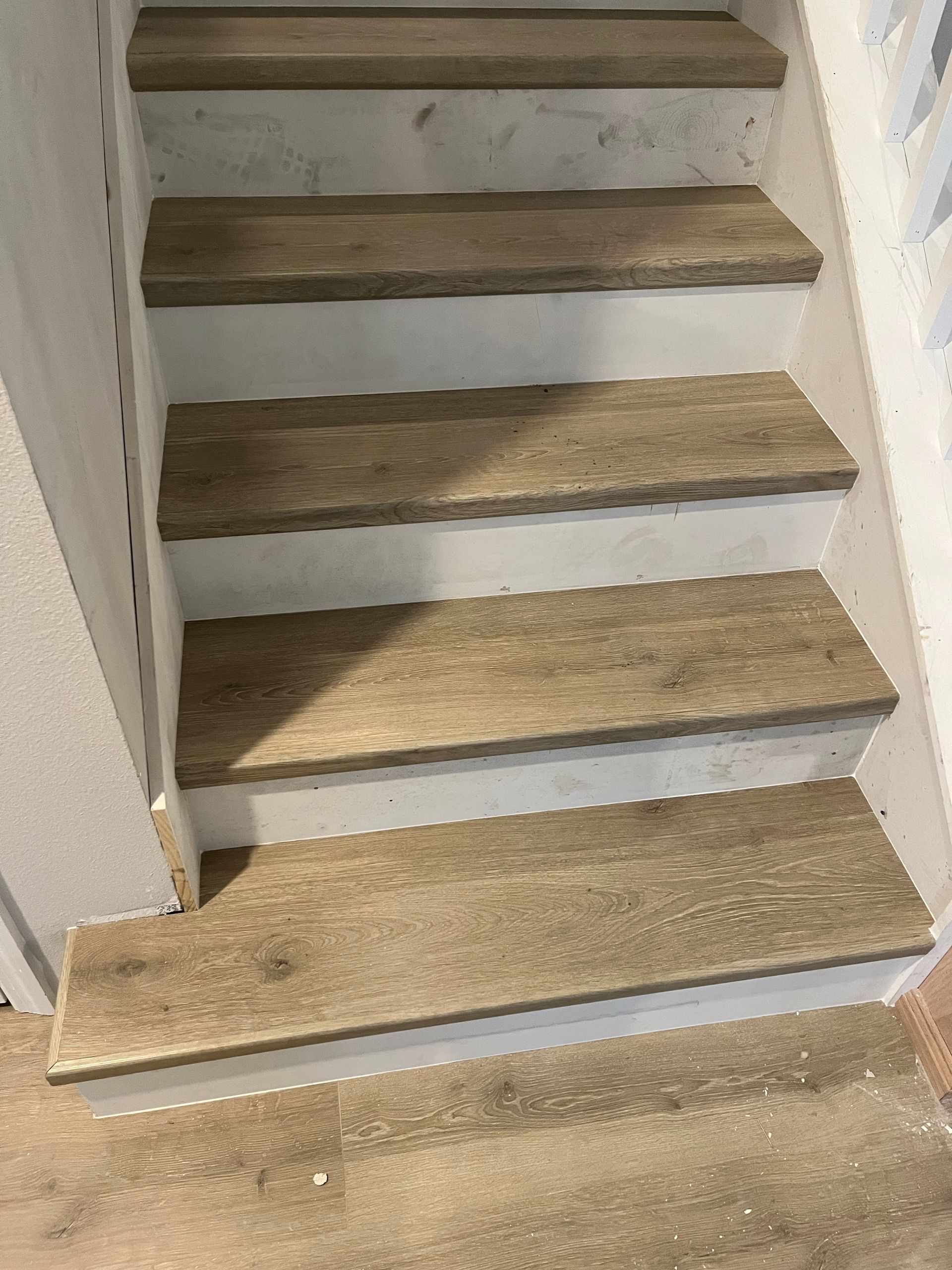 Wooden stair treads against white risers, leading upward.