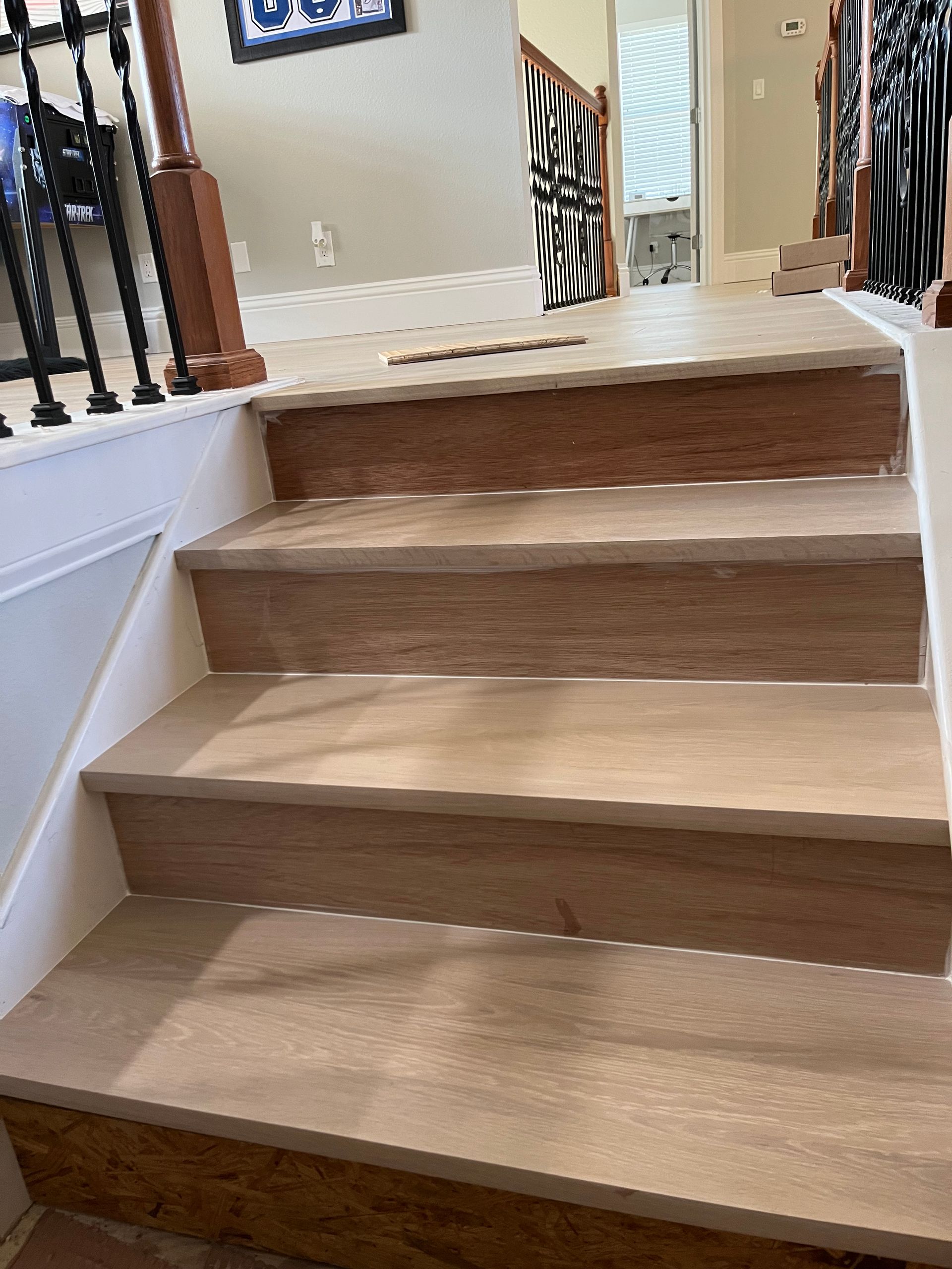 Wooden staircase with white risers and a dark wood railing.