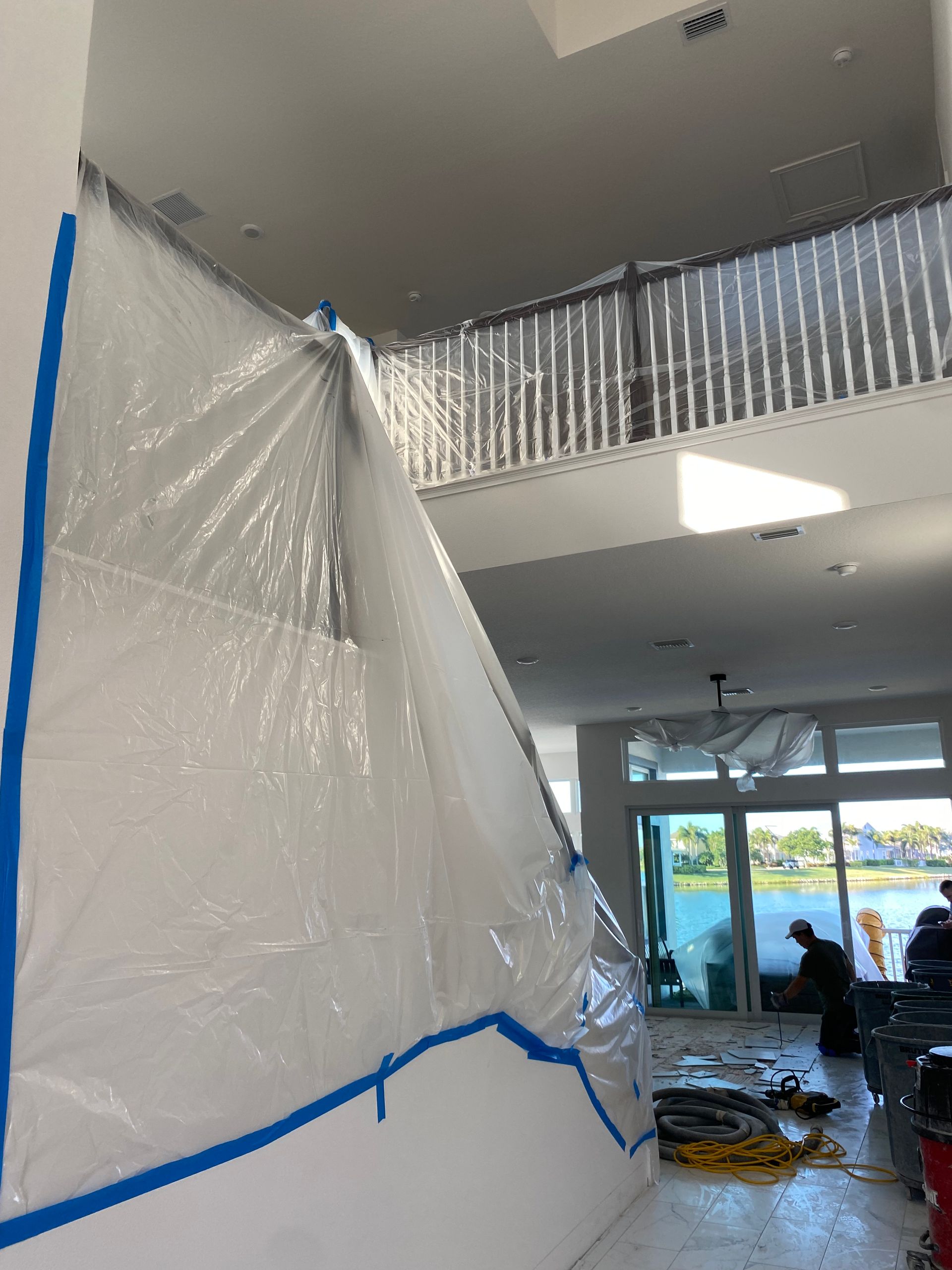 Plastic sheeting taped to walls protects a large interior space during renovation.